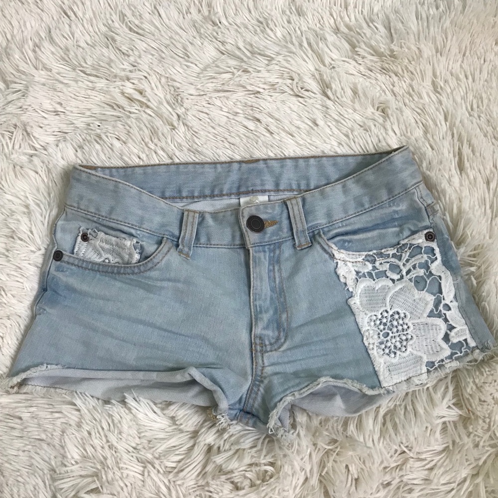 Light washed shorts with a lace flower design.